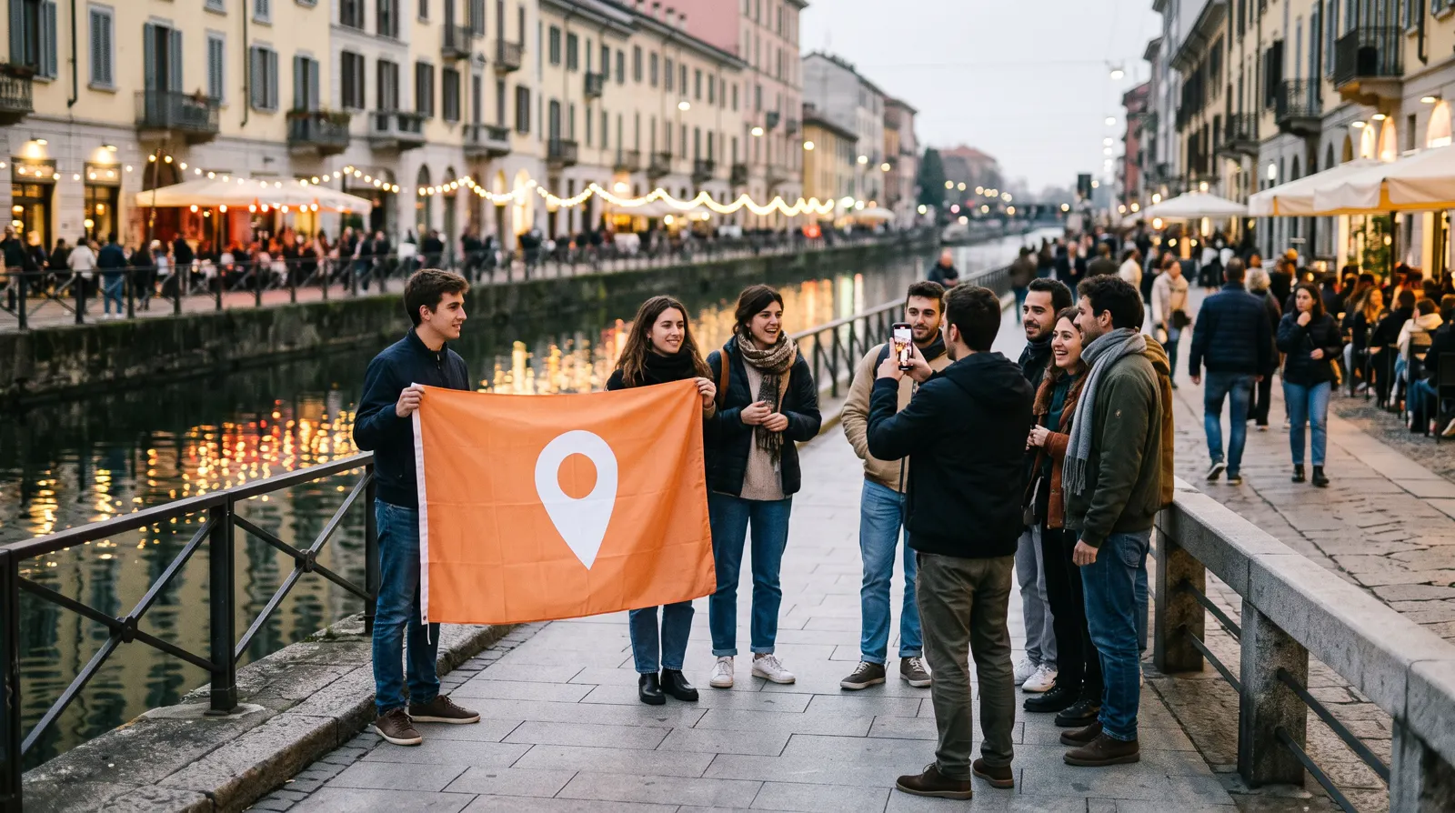 A community meetup on the Navigli canal in Milan with an orange banner